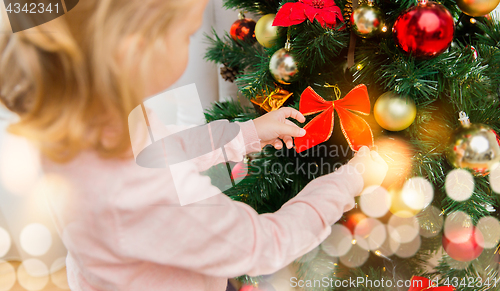 Image of close up of little girl decorating christmas tree