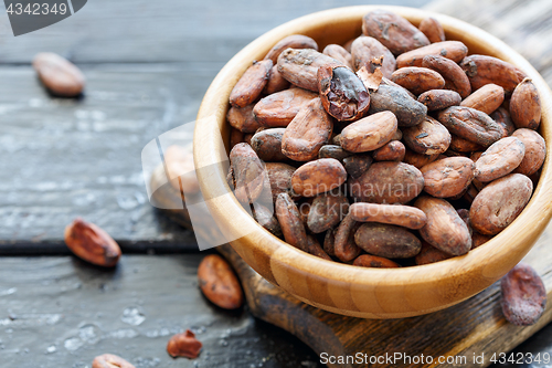 Image of Fragrant cocoa beans in wooden bowl closeup.