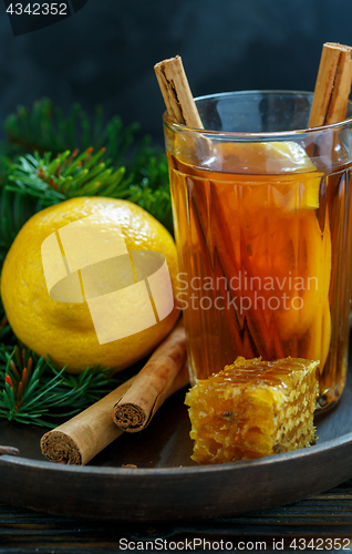Image of Hot tea with spices and lemon on a wooden tray.