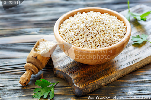 Image of Pearl barley in a wooden bowl and scoop with barley.