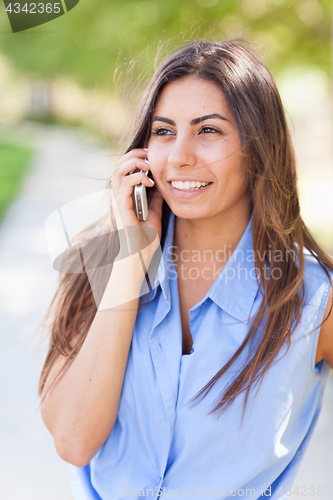 Image of Beautiful Young Ethnic Woman Talking on Her Smartphone Outside.