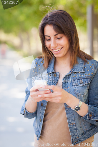 Image of Beautiful Young Ethnic Woman Using Her Smartphone Outside.