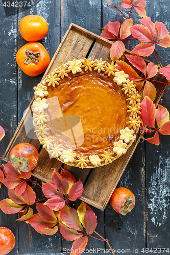 Image of Homemade pumpkin pie on a wooden box.