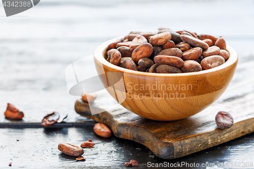 Image of Raw cacao beans in a wooden bowl.