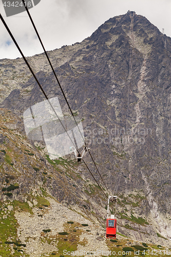 Image of Wagon cable car against the background of beautiful rocky mountains