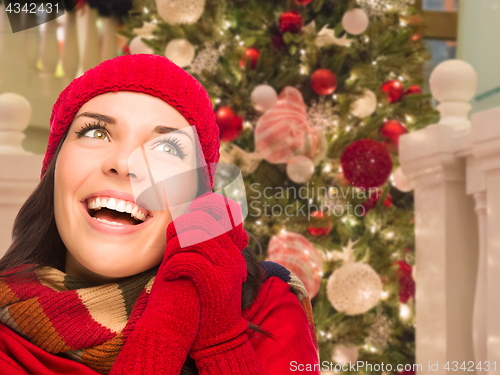 Image of Warmly Dressed Female In Front of Decorated Christmas Tree.