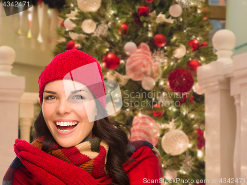 Image of Warmly Dressed Female In Front of Decorated Christmas Tree.