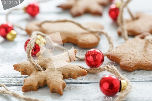 Image of Garland from gingerbread and red Christmas balls closeup.