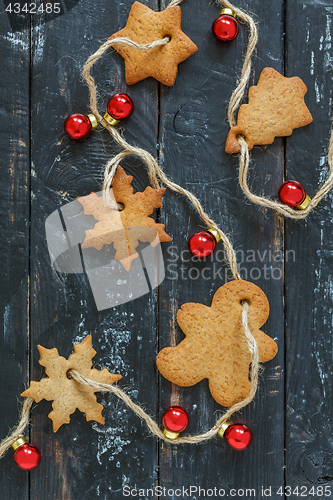Image of Christmas garland from gingerbread and red balls.