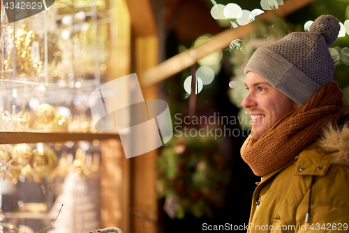 Image of happy man looking at christmas market shop window