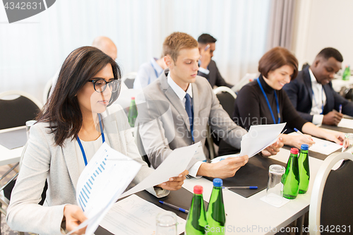 Image of businesspeople with papers at conference
