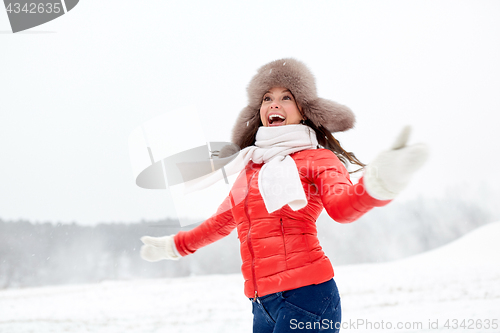 Image of happy woman in winter fur hat having fun outdoors