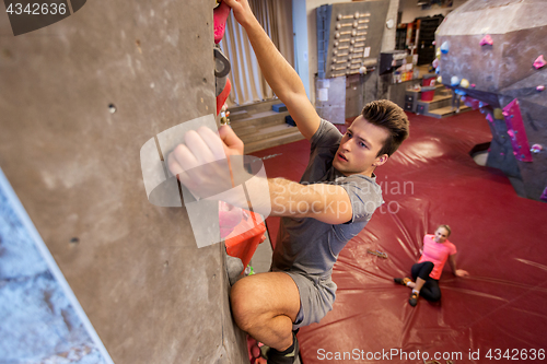 Image of man and woman exercising at indoor climbing gym