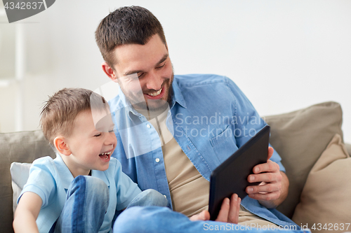 Image of father and son with tablet pc playing at home