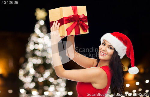 Image of beautiful woman in red dress with christmas gift