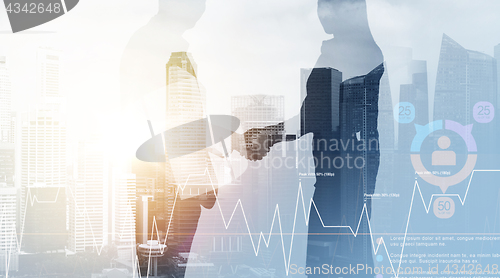 Image of business people shaking hands over city background