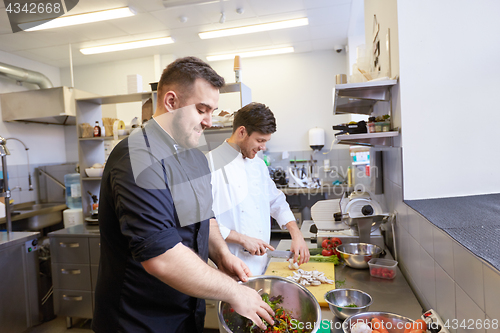 Image of chef and cook cooking food at restaurant kitchen