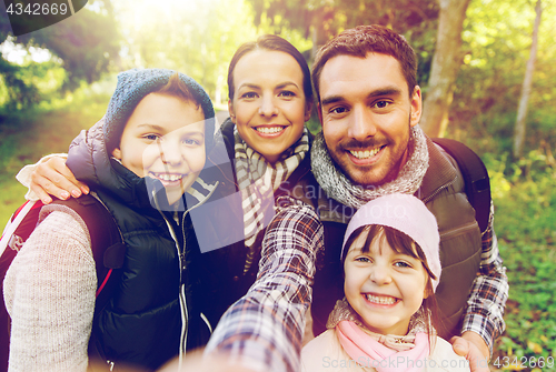 Image of family with backpacks taking selfie and hiking