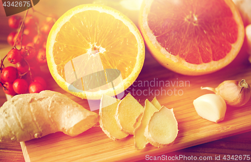 Image of citrus, ginger, garlic and rowanberry on wood