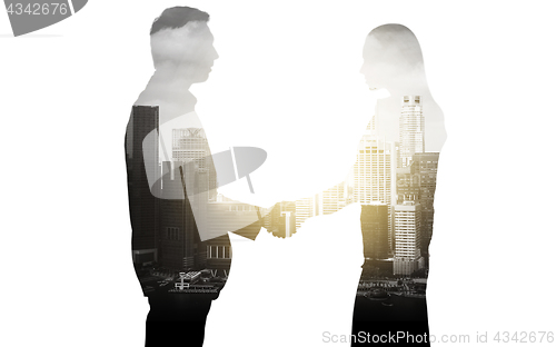 Image of business people shaking hands over city background