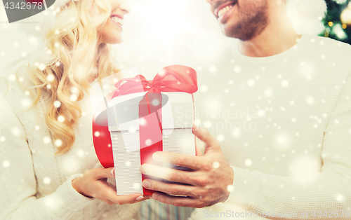 Image of close up of couple with christmas gift at home