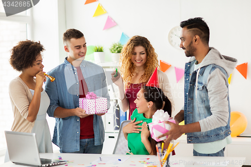 Image of team greeting colleague at office birthday party