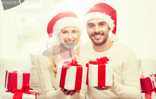 Image of happy couple at home with christmas gift boxes