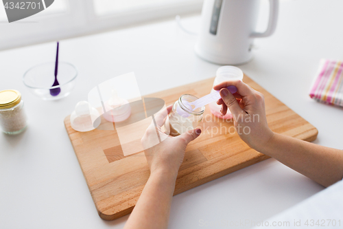 Image of hands with infant formula making baby milk