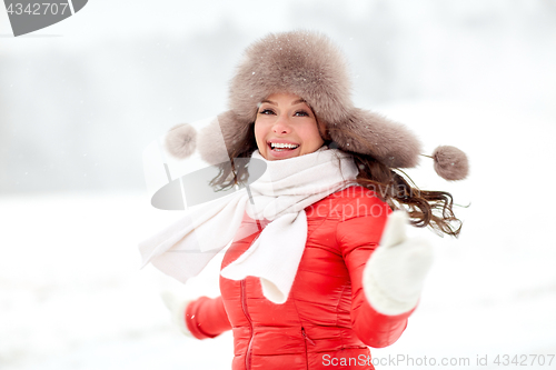 Image of happy woman in winter fur hat outdoors