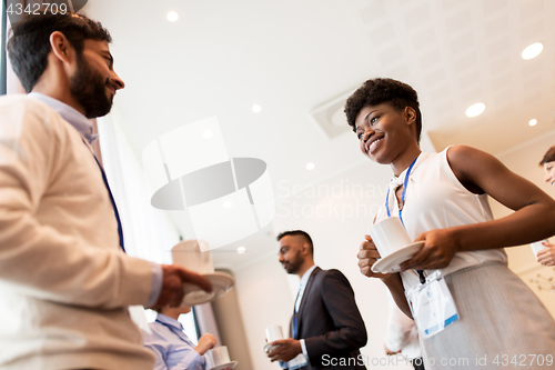 Image of business people with conference badges and coffee