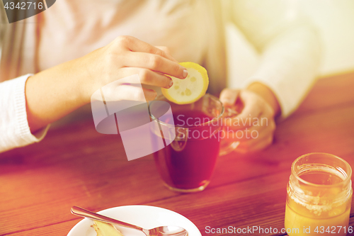 Image of close up of ill woman drinking tea with lemon