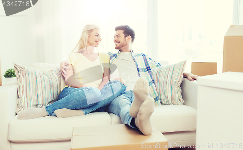 Image of happy couple with big cardboard boxes at new home