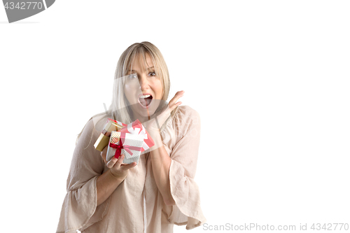 Image of Surprised woman holding wrapped gifts on white background