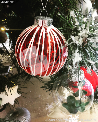 Image of Christmas baubles and other decorations on a snowy Christmas tre
