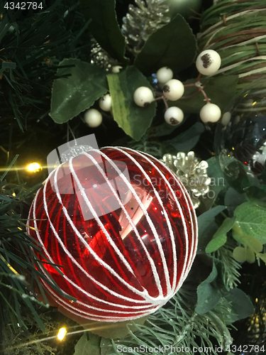 Image of Red and white glass Christmas tree ornament bauble on a tree