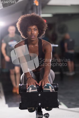 Image of black woman doing sit ups at the gym