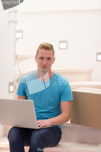 Image of young man sitting in stairway at home