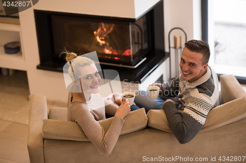 Image of Young couple  in front of fireplace