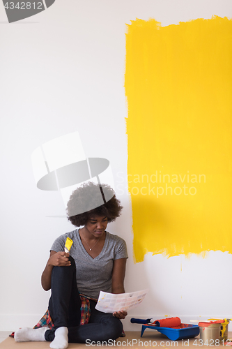 Image of back female painter sitting on floor