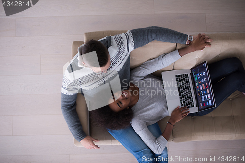 Image of happy multiethnic couple relaxes in the living room