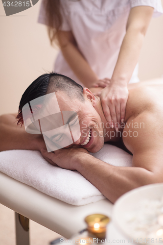 Image of young man having a back massage