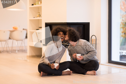 Image of multiethnic couple  in front of fireplace