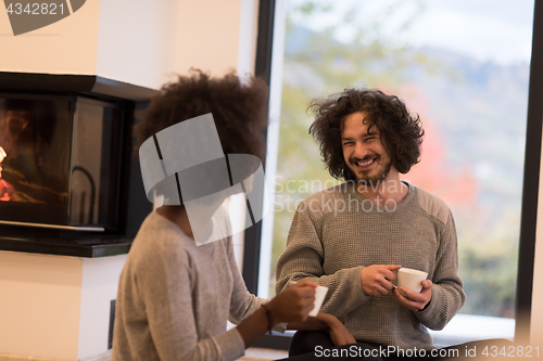 Image of multiethnic couple  in front of fireplace