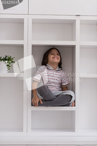 Image of young boy posing on a shelf