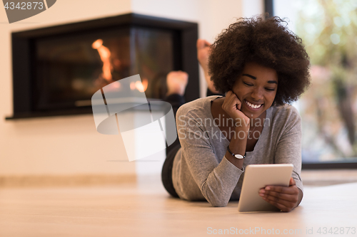 Image of black women using tablet computer on the floor