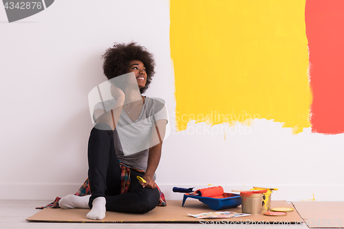 Image of back female painter sitting on floor