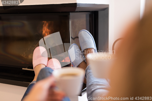 Image of Young multiethnic couple  in front of fireplace