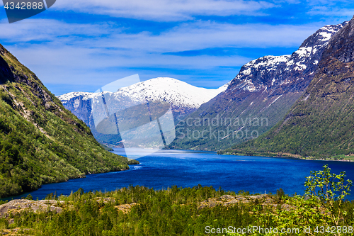 Image of A beautiful spring day with snow on the mountain peaks, blue sky