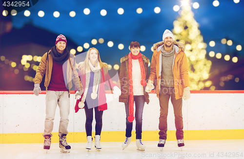 Image of happy friends on christmas skating rink