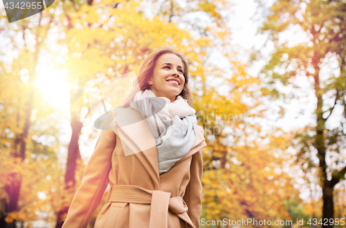 Image of beautiful happy young woman walking in autumn park